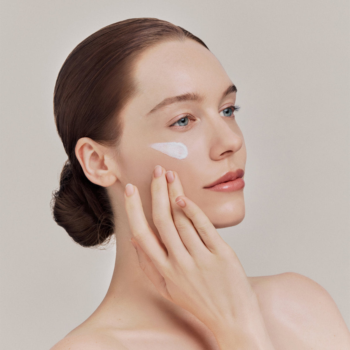 Frau trägt Gesichtscreme auf die Wange auf – Kollektion Gesichtspflege bei Curantus Naturkosmetik Münster
