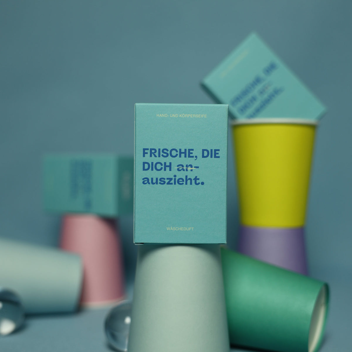 KLAR Duschseife Wäscheduft – Verpackung zwischen bunten Bechern