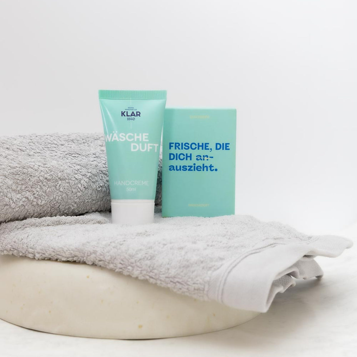 KLAR Handcreme Wäscheduft – Tube mit Duschseife Wäscheduft auf Handtuch