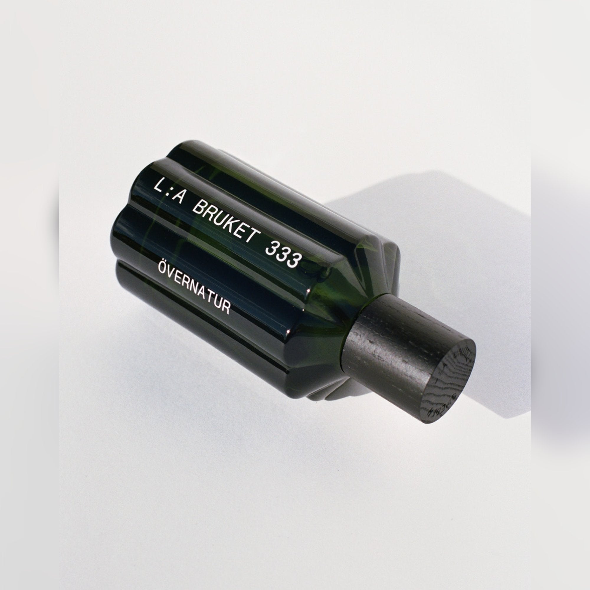 L:A BRUKET Övernatur Eau de Parfum – Flakon liegend mit Schattenwurf
