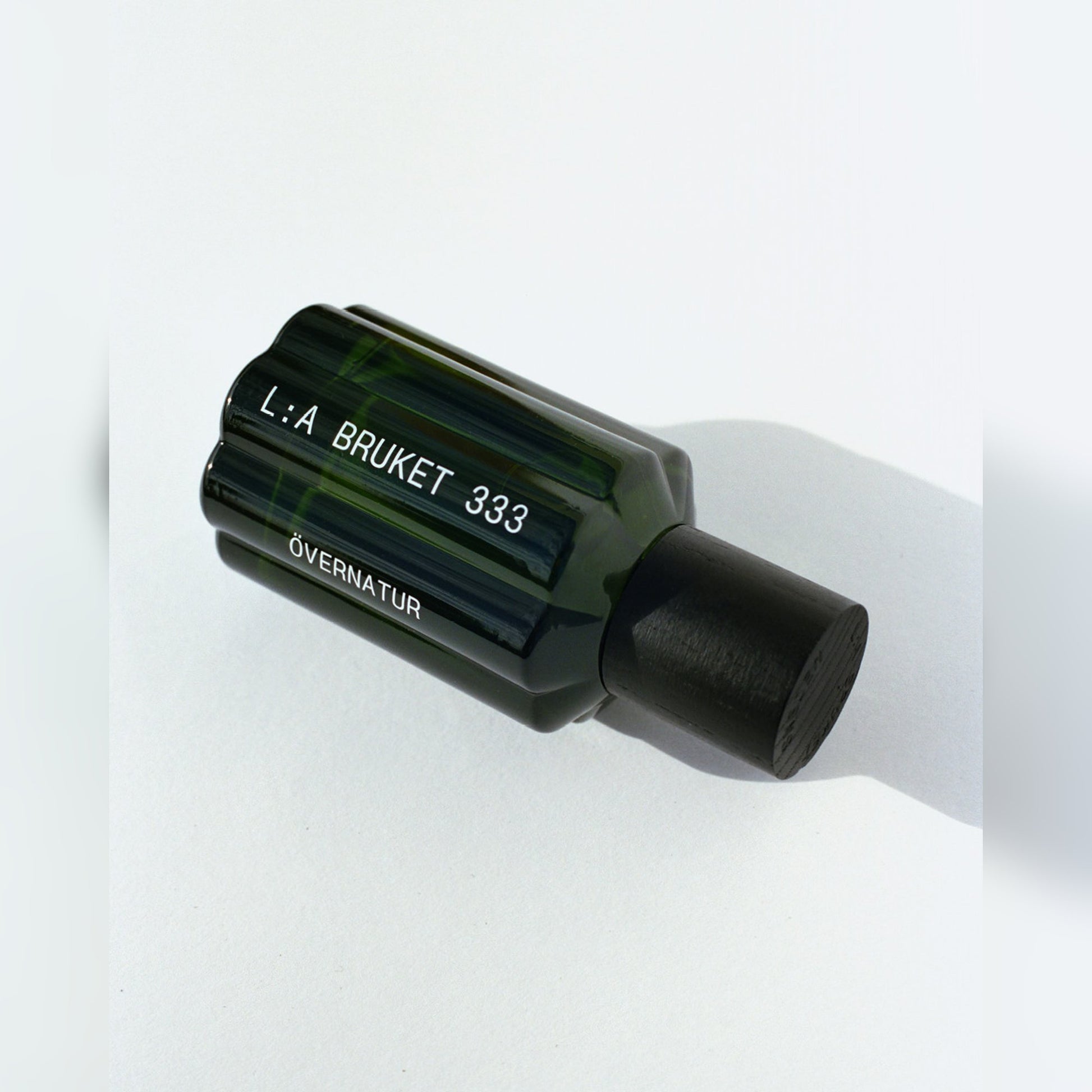 L:A BRUKET Övernatur Eau de Parfum – Flakon liegend mit Schattenwurf