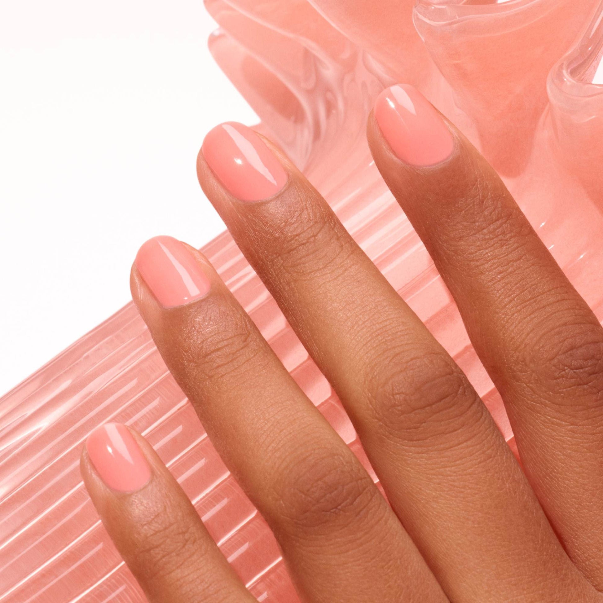 Manucurist Glacé Jelly – Hand mit koralle schimmernden Nägeln, Jelly-Finish
