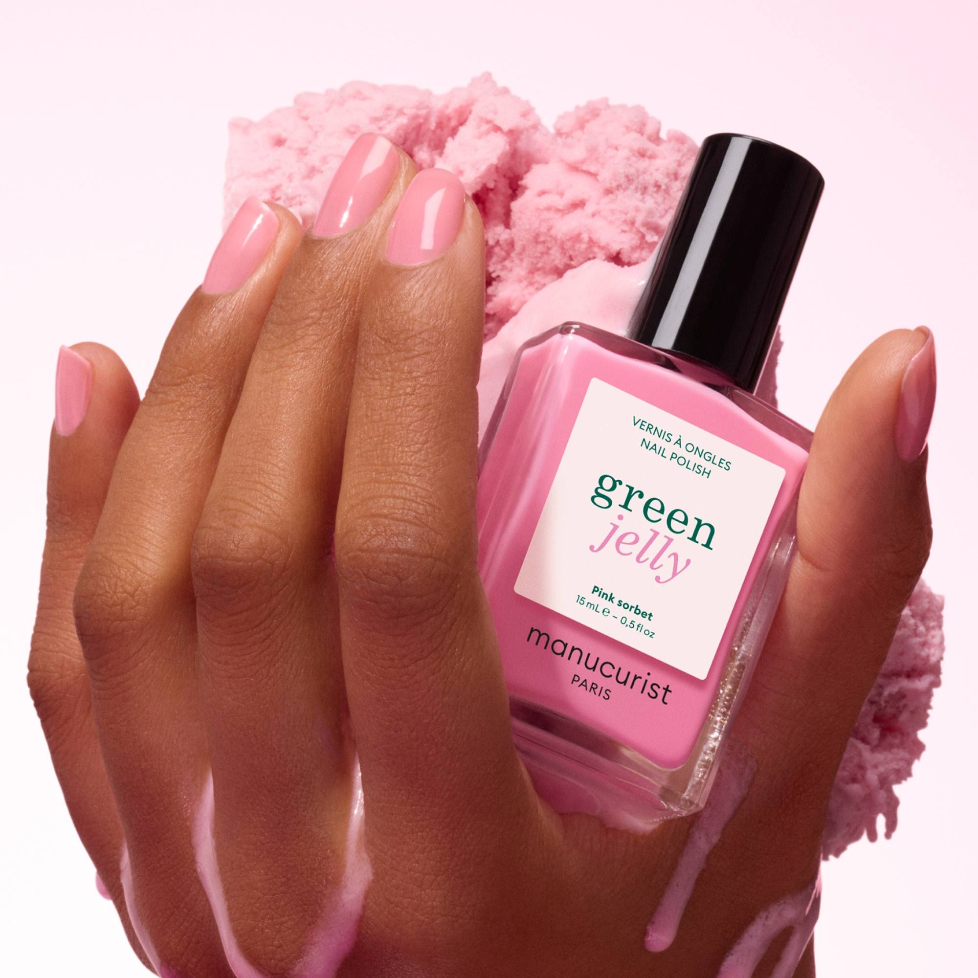 Manucurist Pink Sorbet Jelly – Hand hält den Flakon über rosa Puder