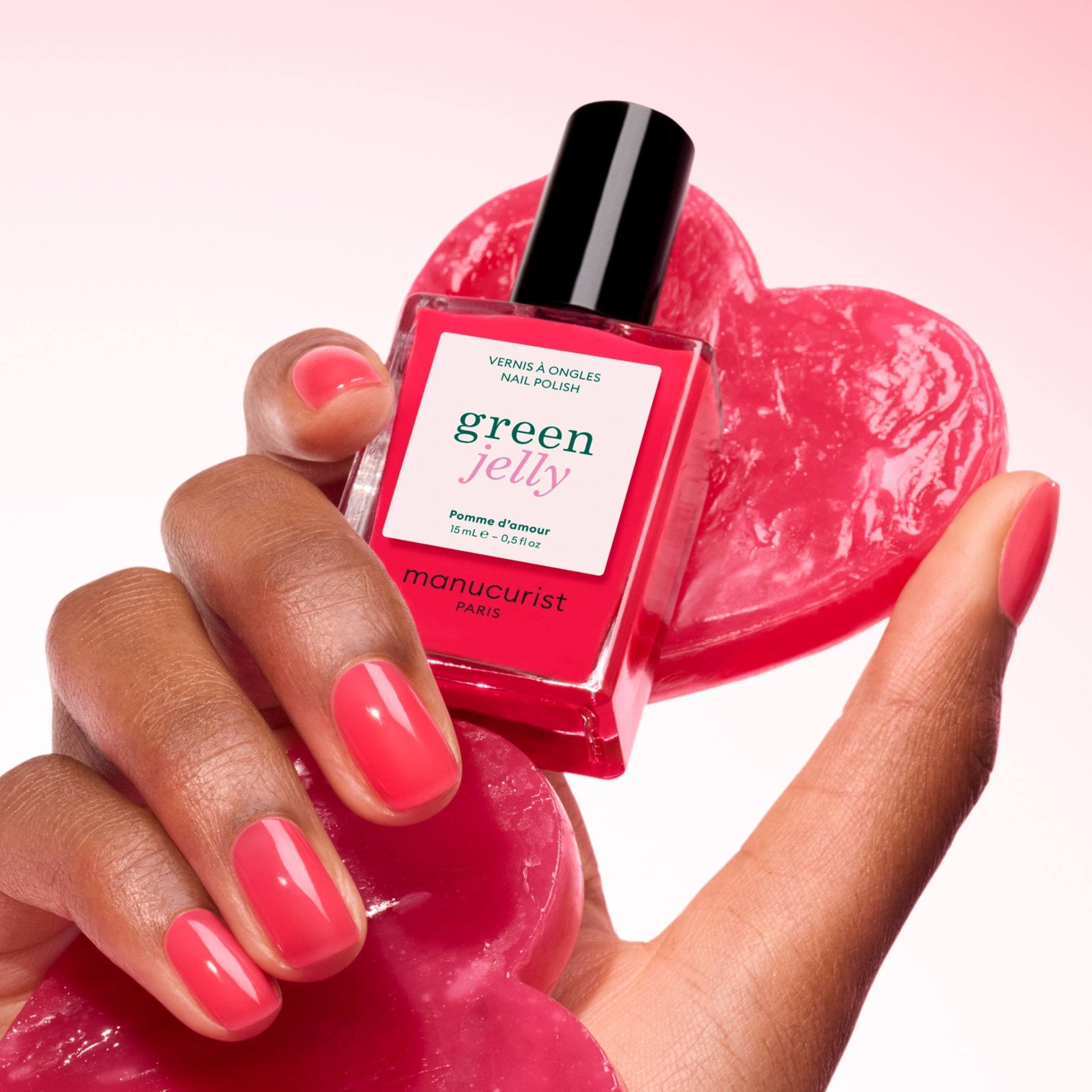 Manucurist Pomme d'Amour Jelly – Hand hält den Flakon über einem roten Herz