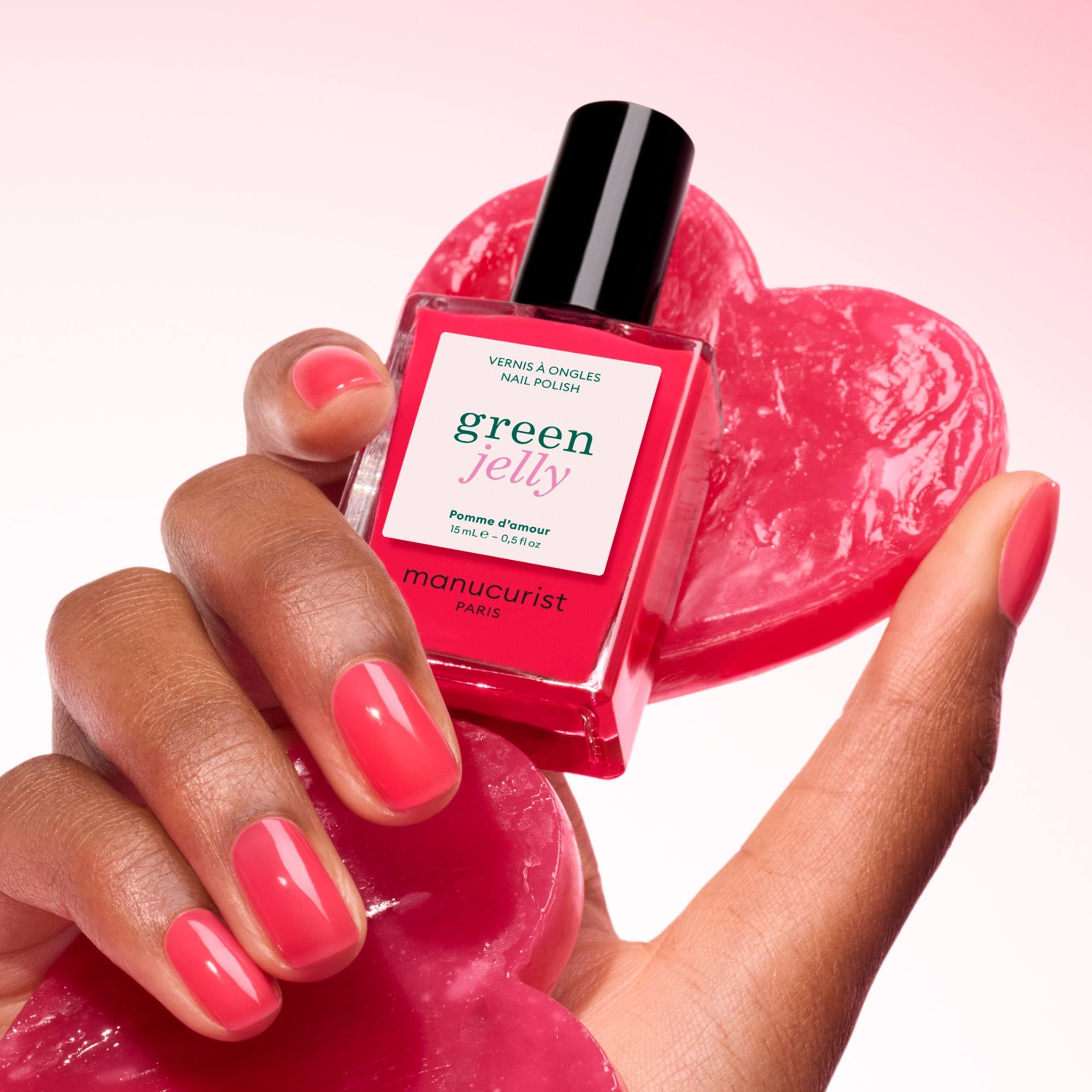 Manucurist Pomme d'Amour Jelly – Hand hält den Flakon über einem roten Herz