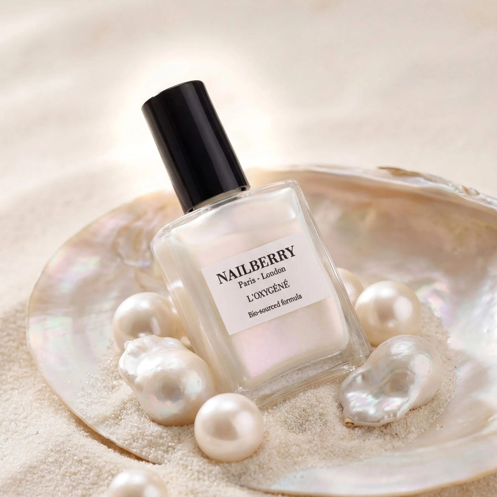 Flasche Nagellack in einer Muschel, umringt von Perlen