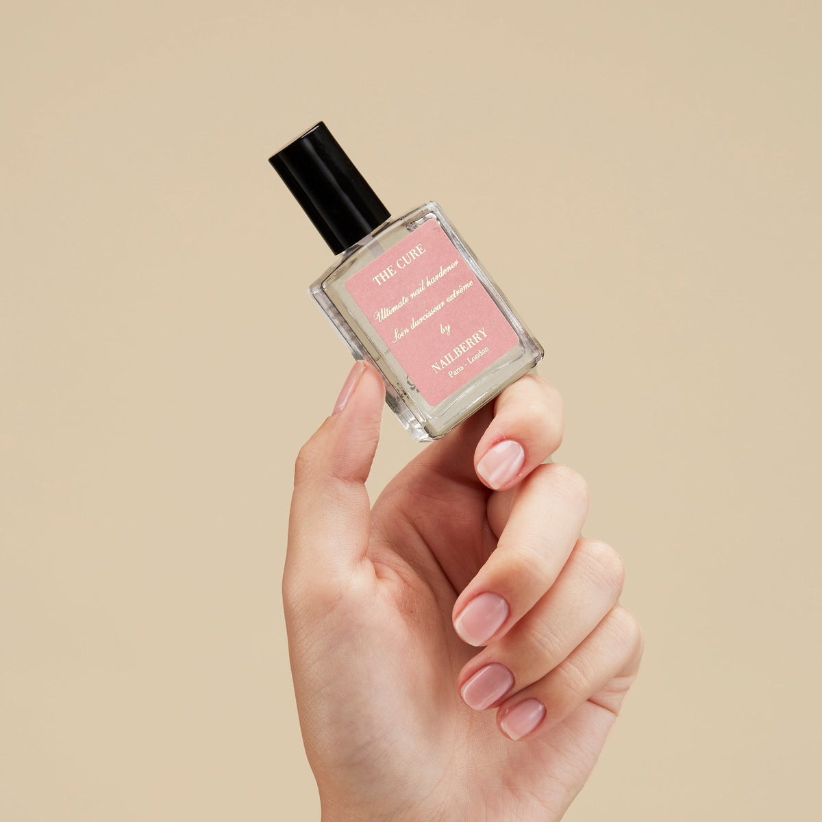Nailberry The Cure Nail Hardener, 15ml – Flasche in der Hand vor hellem Grund