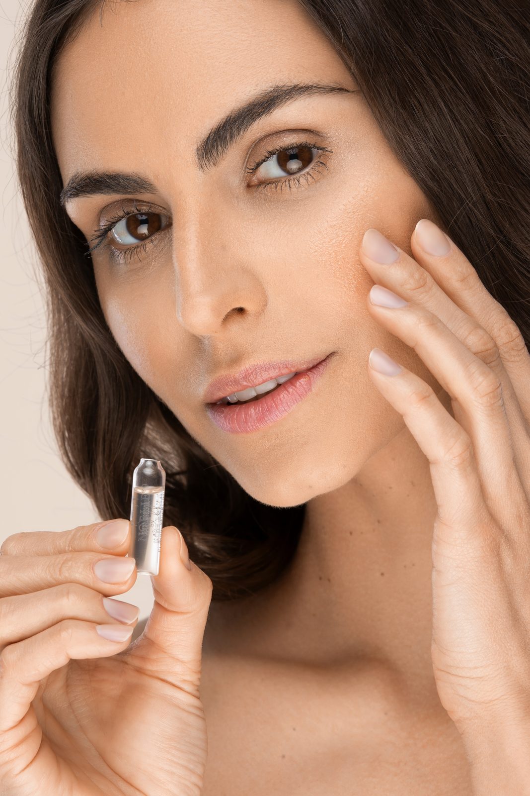 NOELIE Bio-Wirkstoffkosmetik — Anwendung einer Ampullen-Kur auf der Haut, Hero-Bild der Markenseite bei Curantus