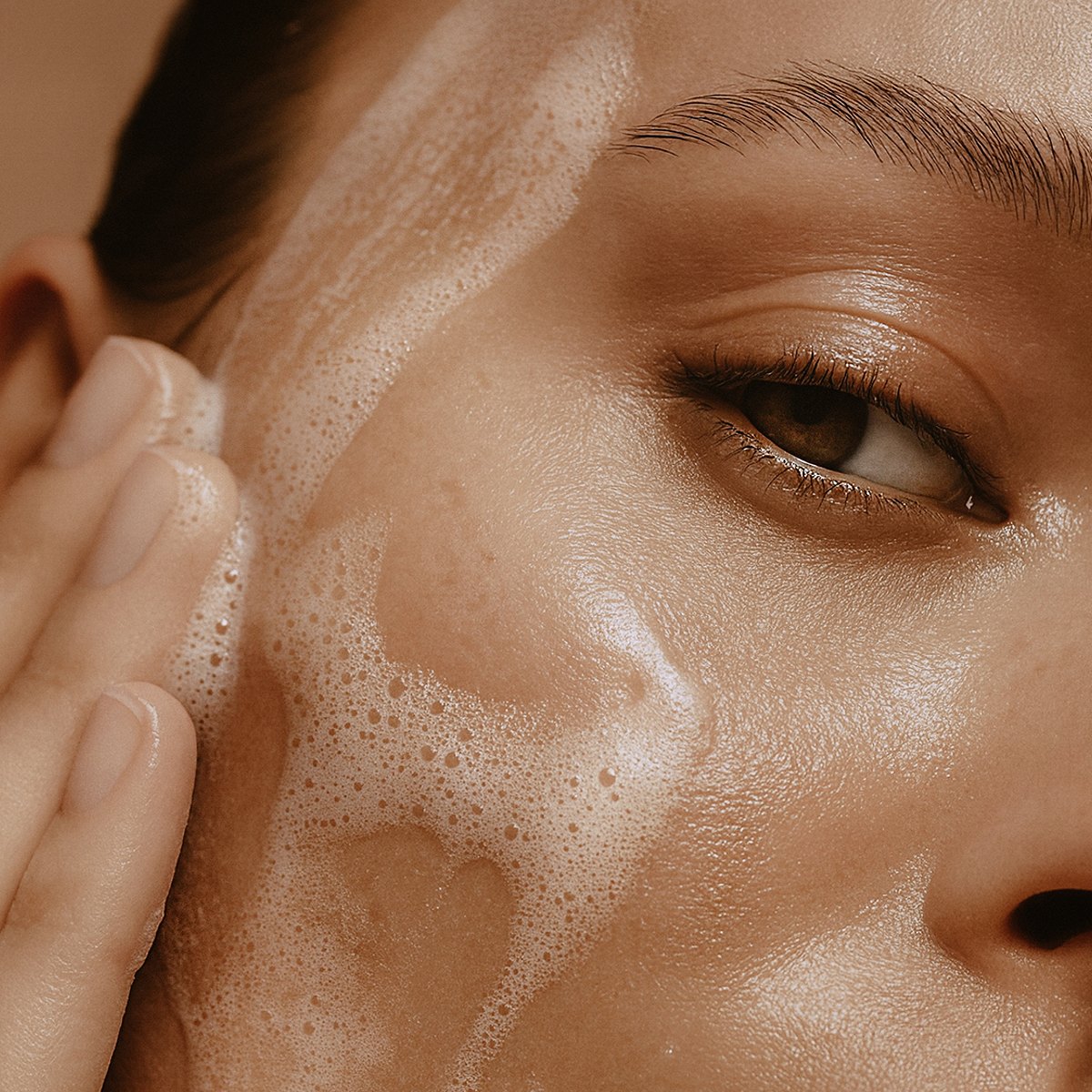 Anwendung: aufgeschäumtes NOELIE Purifying & Balancing Face Cleansing Gel auf der Gesichtshaut, Nahaufnahme