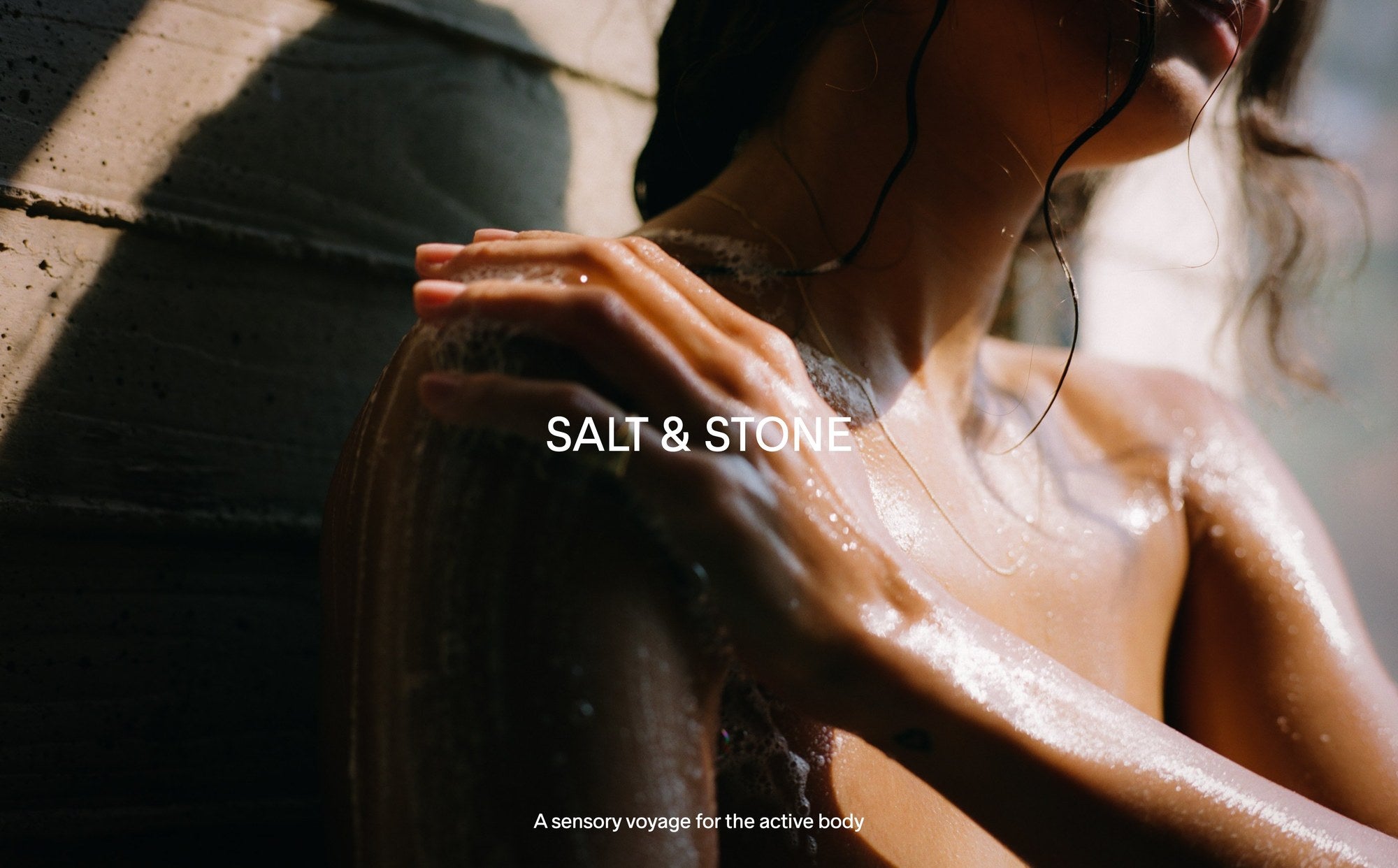 Salt & Stone Hero — sensorisches Body Care, Frau in der Dusche mit Sonnenlicht