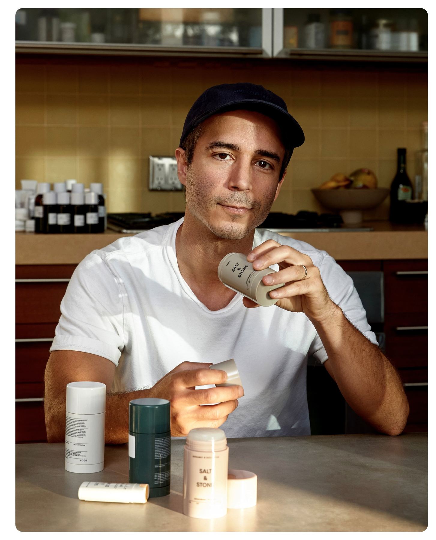 Nima Jalali, Gründer von Salt & Stone — Portrait am Tisch mit Deodorant-Stick