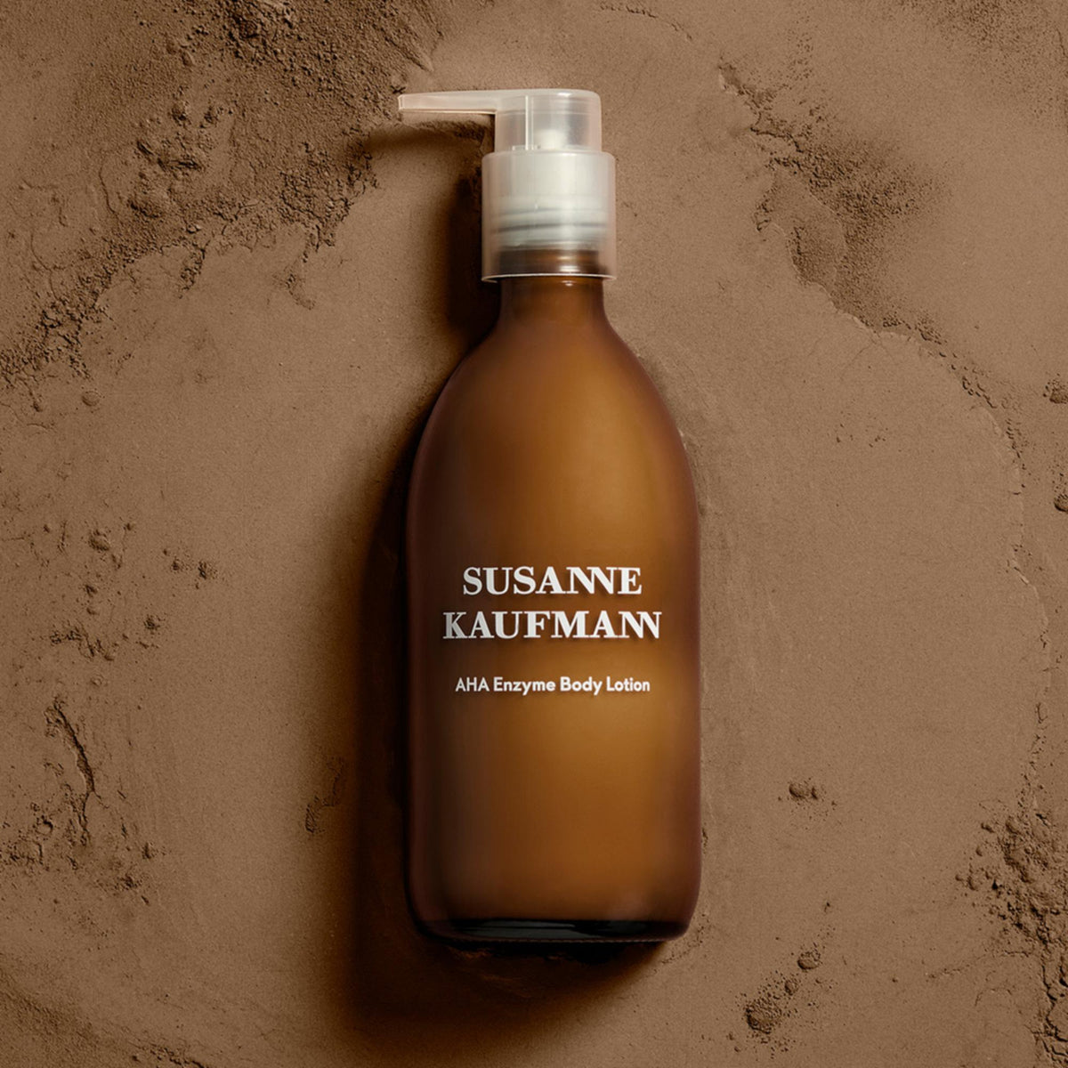 Susanne Kaufmann AHA Enzyme Body Lotion / AHA-Enzym-Körperlotion, 250ml – Flasche auf hellem Sand