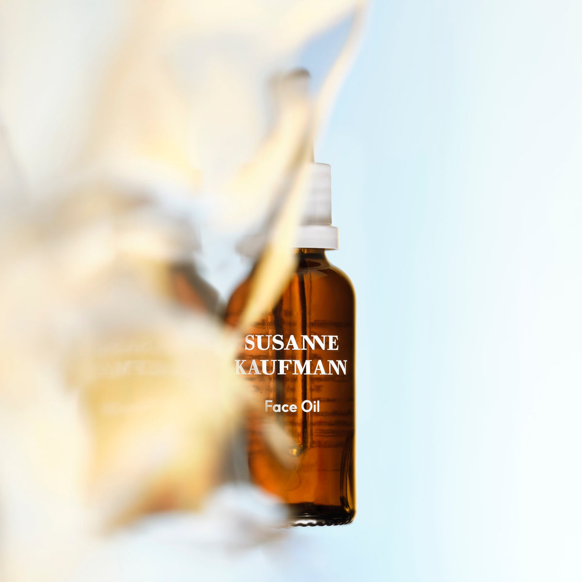 Susanne Kaufmann Face Oil / Gesichtsöl, 30ml – Flasche vor goldenem Licht