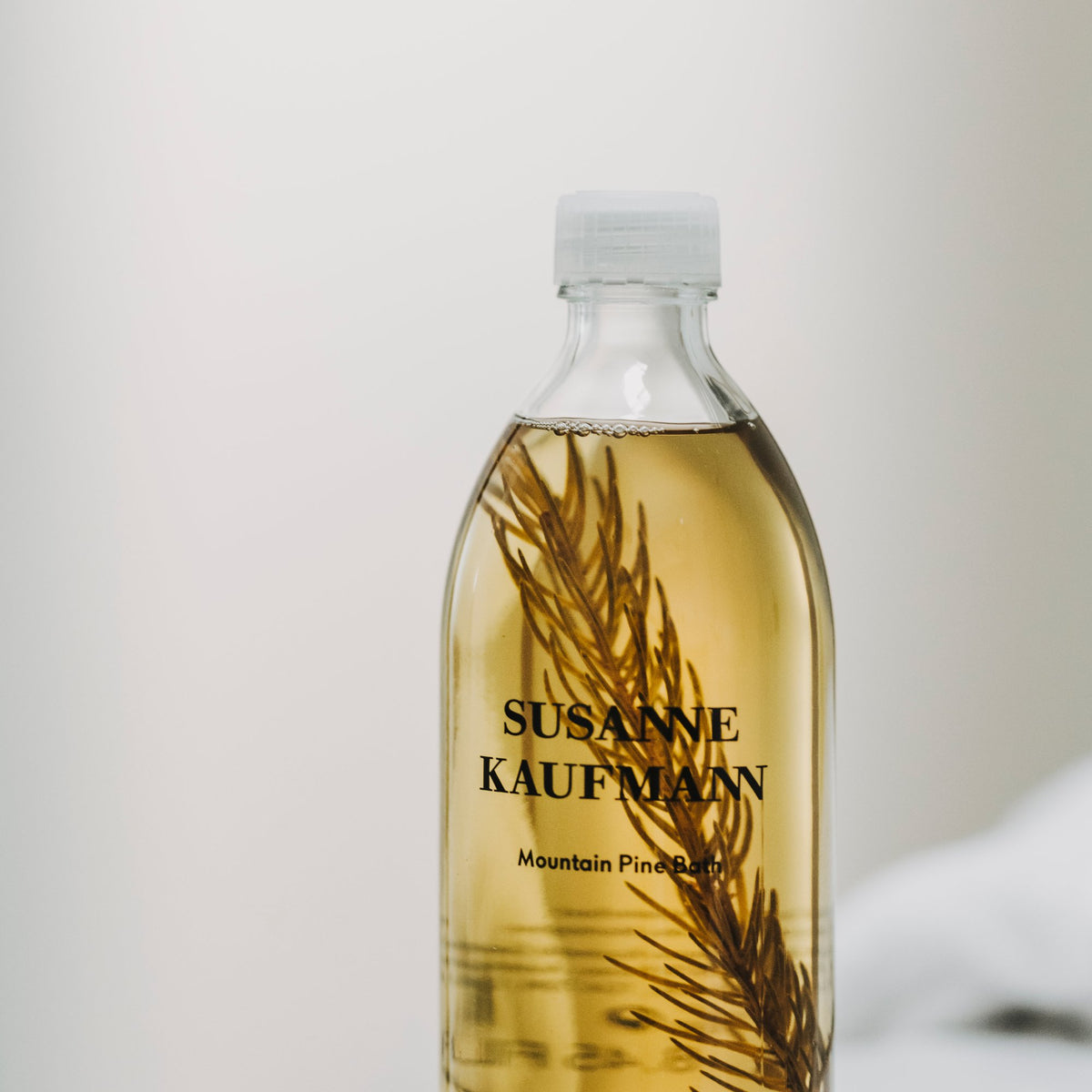 Susanne Kaufmann Mountain Pine Bath / Latschenkieferbad, 250ml – Flasche mit Kiefernzweig am Badewannenrand
