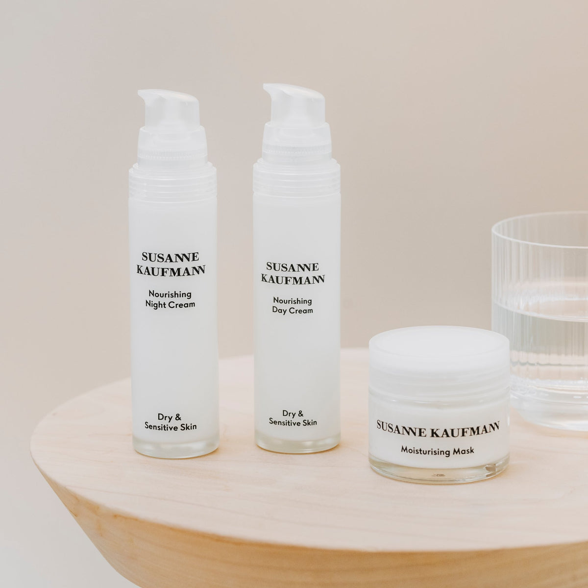 Susanne Kaufmann Nourishing Night Cream / Nährende Nachtcreme, 50ml – mit Nährender Tagescreme und Feuchtigkeitsmaske auf einem Holztisch