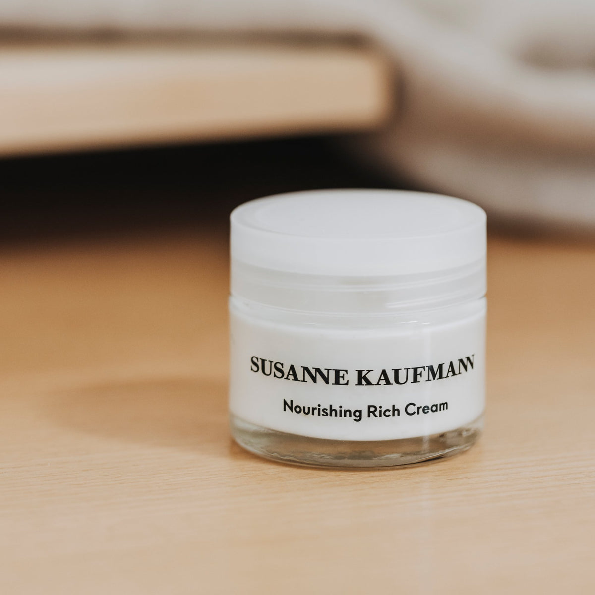 Susanne Kaufmann Nourishing Rich Cream / Reichhaltige Pflegecreme, 50ml – Tiegel auf einem Holztisch
