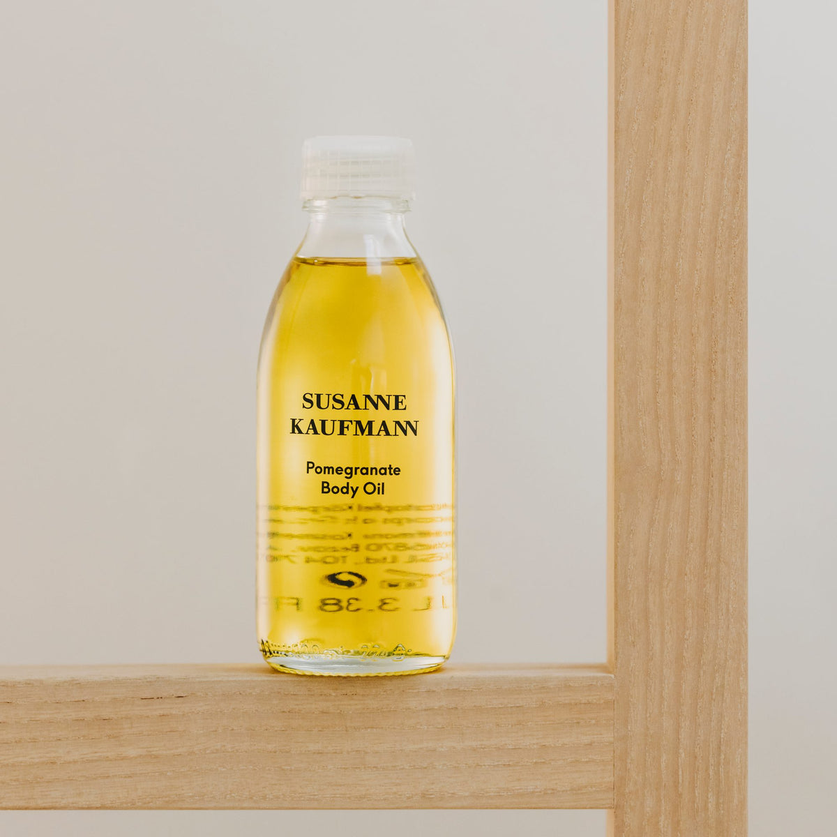 Susanne Kaufmann Pomegranate Body Oil / Granatapfel-Körperöl, 100ml – Flasche auf einem Holzregal